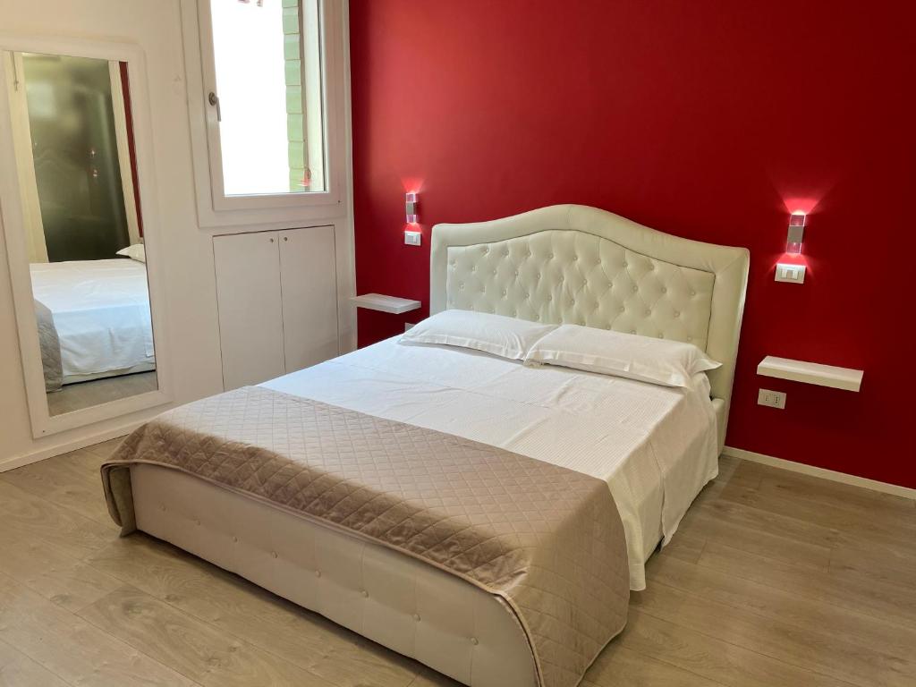 帕多瓦A&F Apartment Padova centro storico的卧室配有白色的床铺和红色的墙壁