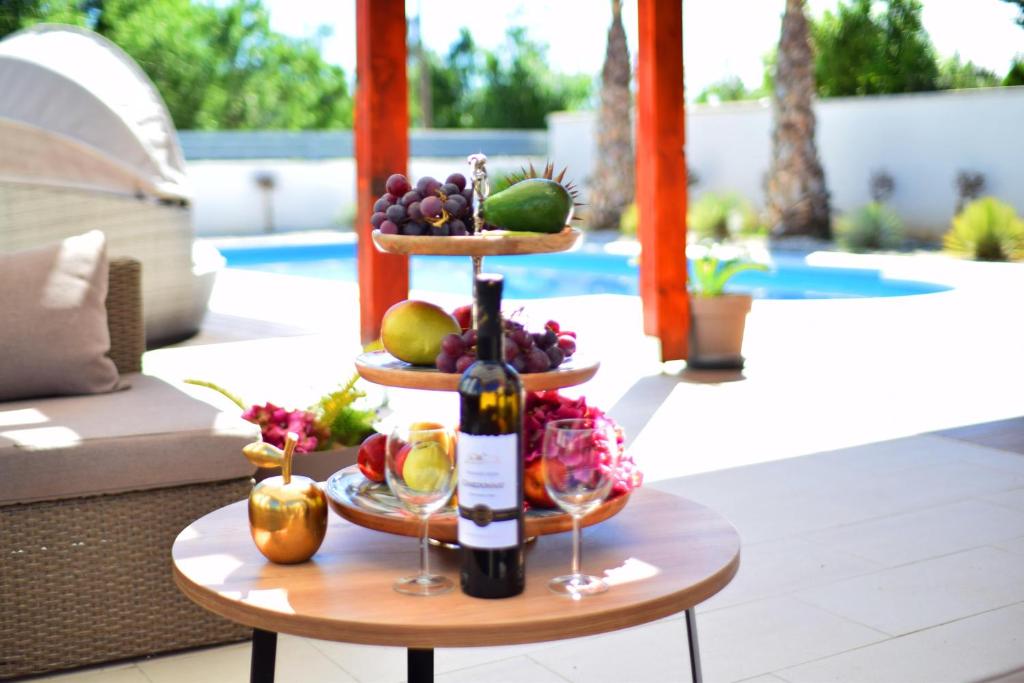 SelineVilla Golden Apple的桌上一瓶葡萄酒和水果
