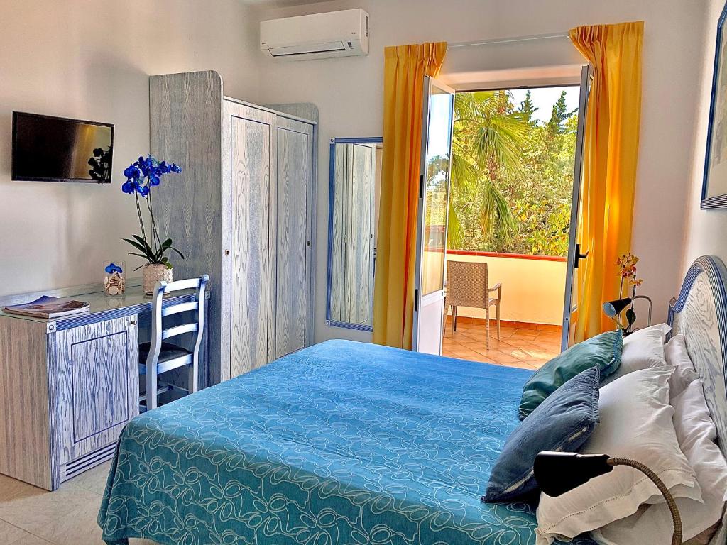 伊斯基亚Resort Villa Flavio的一间卧室配有一张床、一张书桌和一个窗户。