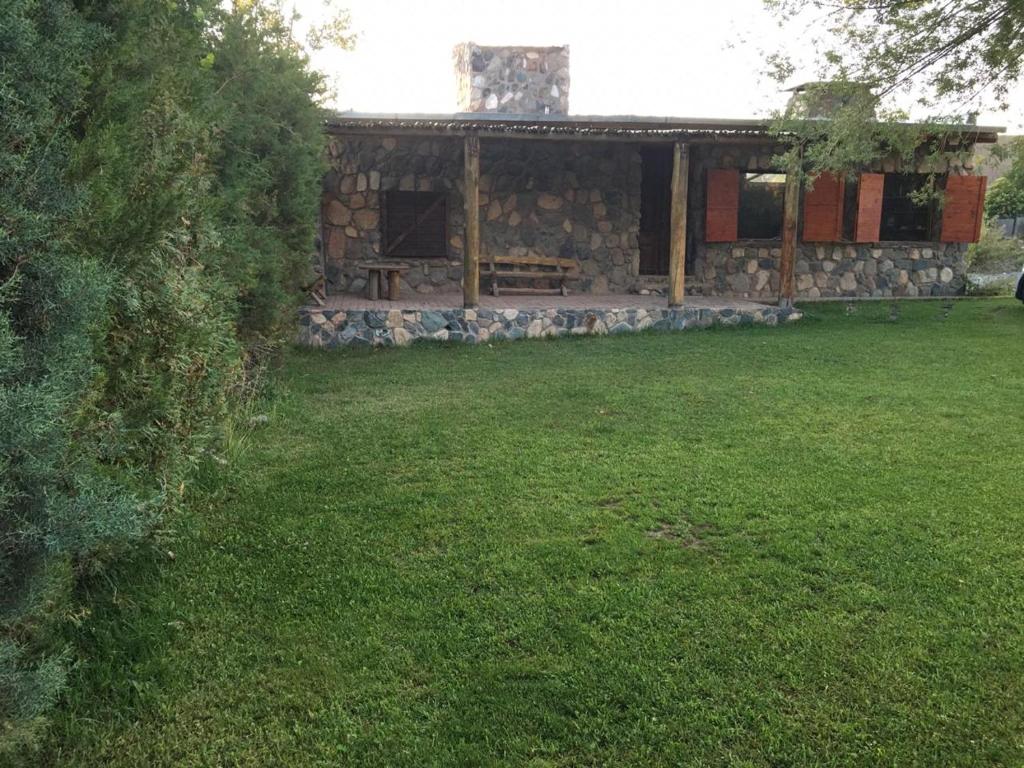 波特雷里约斯UTU TOCO - casa de piedra en lengua Huarpe的庭院内带野餐桌的石头房子