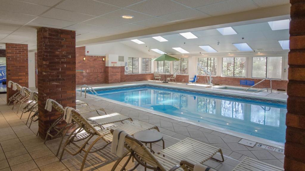 伯灵顿南伯灵顿快捷假日酒店的大楼内带桌椅的大型游泳池
