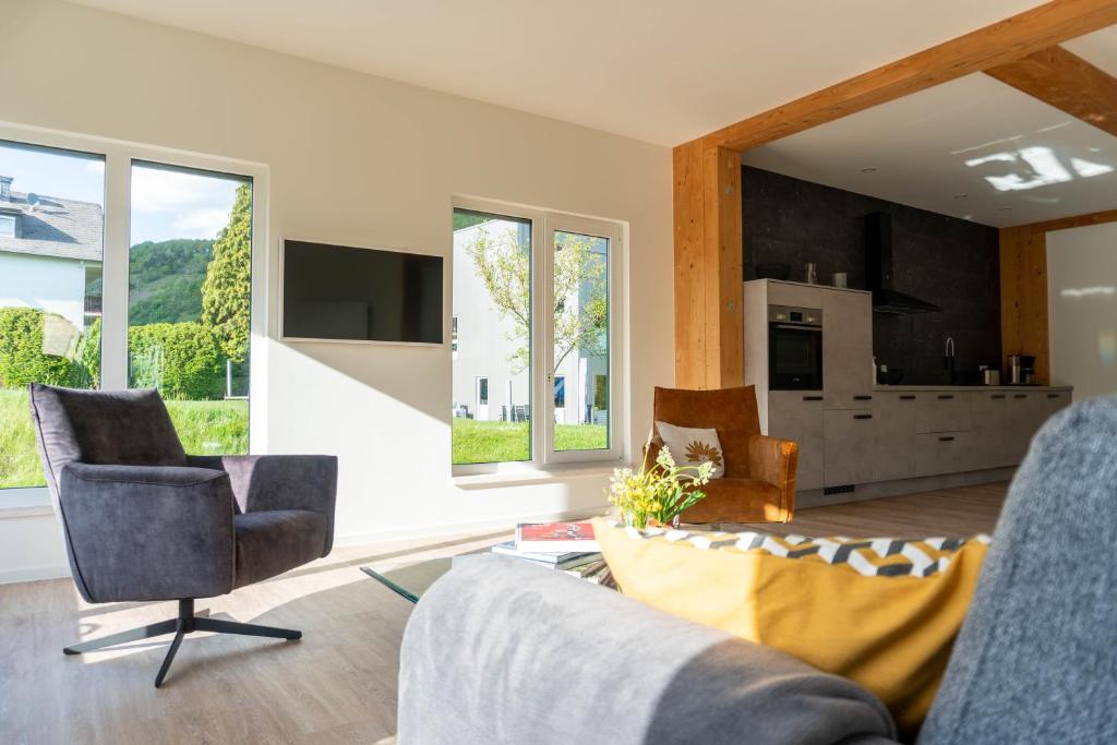 特拉本特拉巴赫Velo & Wohnen -NEU- Elektroräder inklusive - Sauna的带沙发、椅子和窗户的客厅