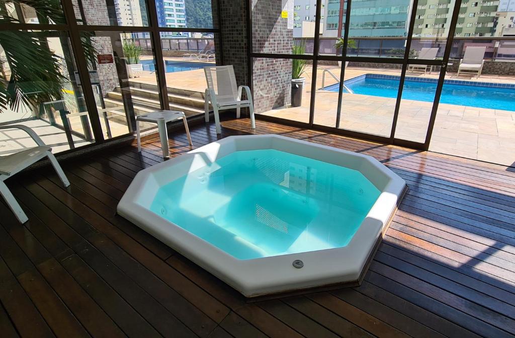 巴拉奈里奥-坎布里乌Costa Sul Beach Hotel的一个带游泳池的甲板上的按摩浴缸