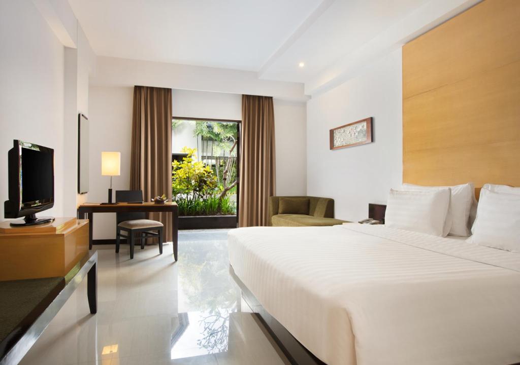玛琅桑提卡玛琅酒店的酒店客房,配有床和电视