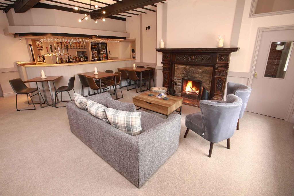 Llansantffraid Glyn Ceiriog格林谷酒店的带沙发和壁炉的客厅以及酒吧。