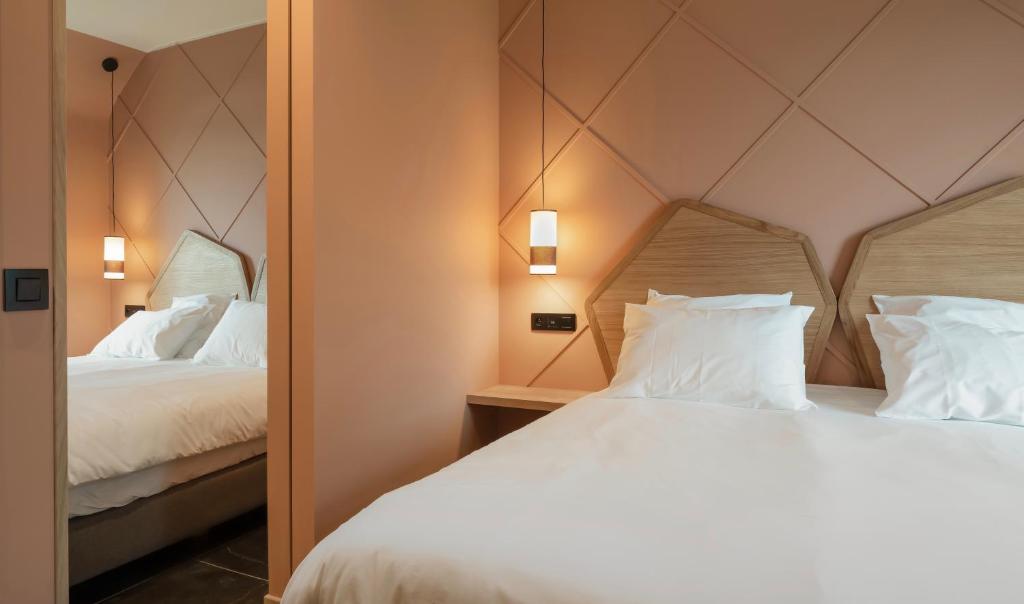 JodoigneLa Villa du Hautsart的一间卧室配有两张带白色枕头和镜子的床