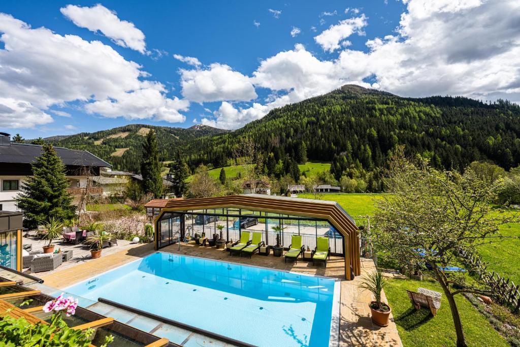 巴德小基希海姆Genusshotel Almrausch的一个带凉亭的室外游泳池,其背景是山脉