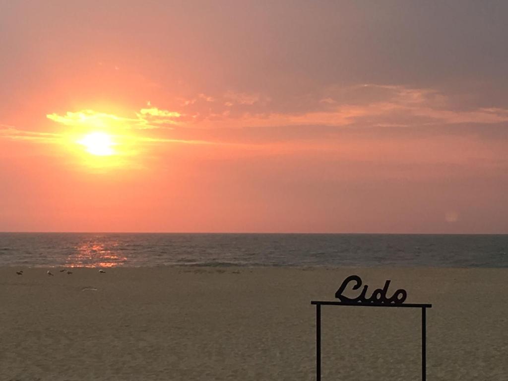 奥斯坦德Theodore Oostende-zorgeloos genieten in stijl op de perfecte locatie的沙滩上的日落,沙滩上有一个标志