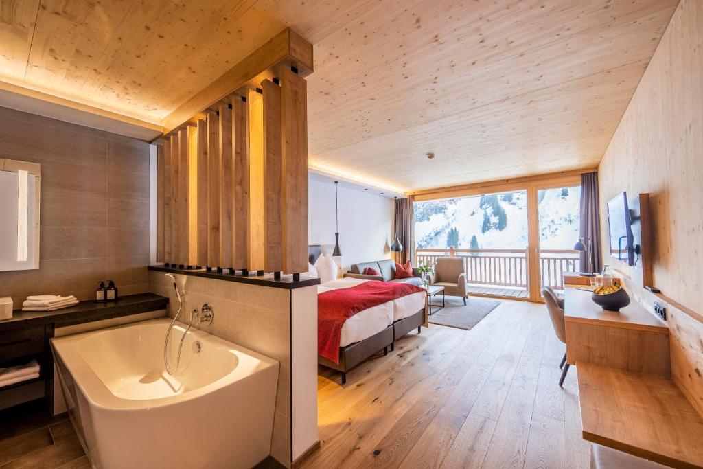 达米尔斯达穆尔森霍夫酒店 - 健康及Spa中心的卧室配有床和浴缸