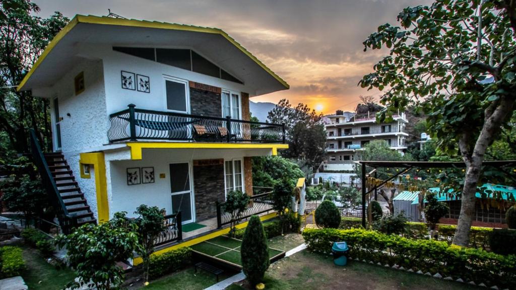 瑞诗凯诗The Hosteller Rishikesh, Tapovan的带阳台和树的白色房屋