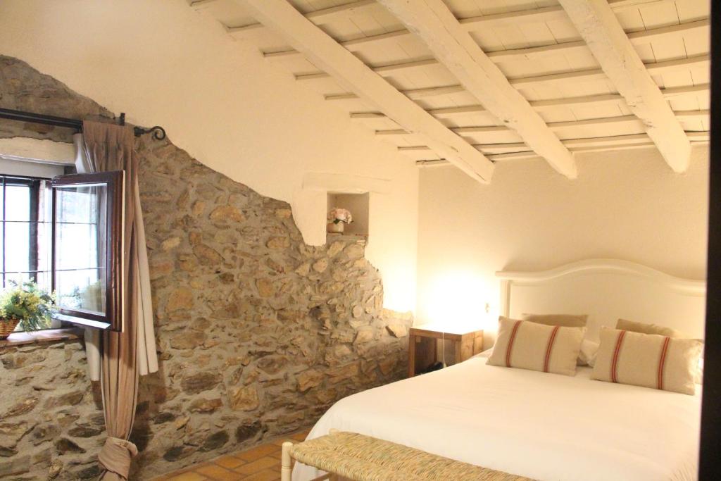 蒙塞尼坎巴林纳酒店的一间卧室设有一张床和石墙