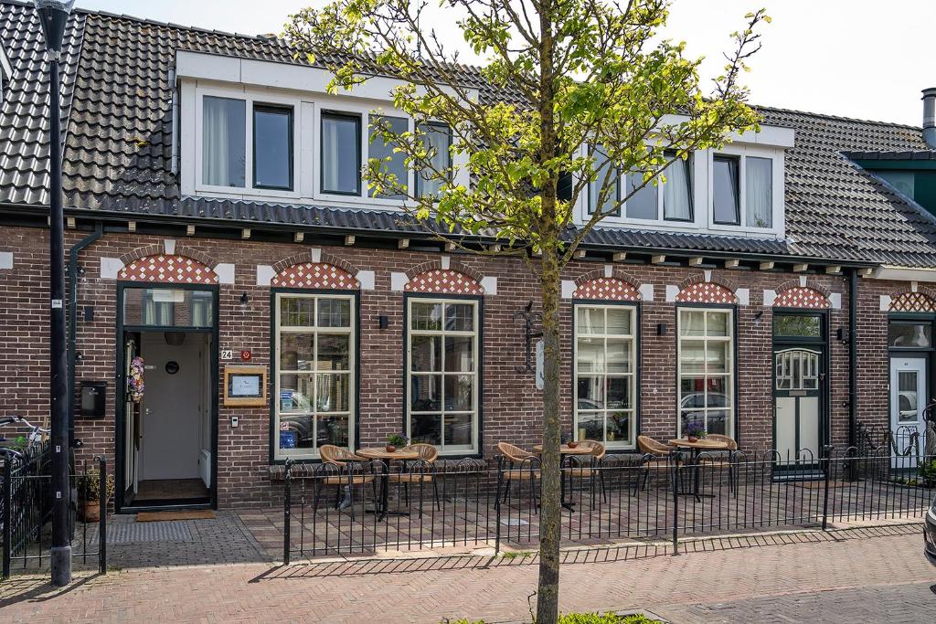 德科克斯多普Hotel het Anker van Texel的前面设有桌椅的砖砌建筑
