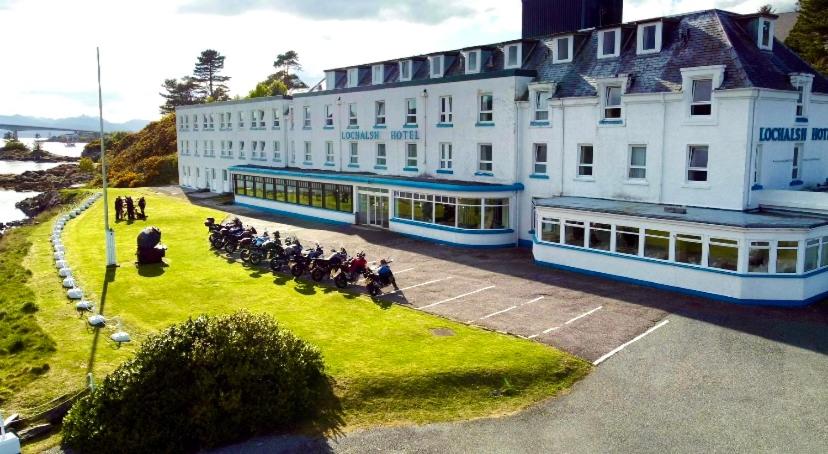 洛哈尔什教区凯尔高地Lochalsh Hotel with Views to the beautiful Isle of Skye的一群骑马的人在一座建筑前