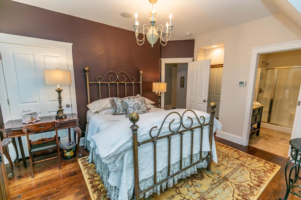 BereaRiverside Gables Bed and Breakfast的一间卧室配有一张床、一张桌子和一个吊灯。