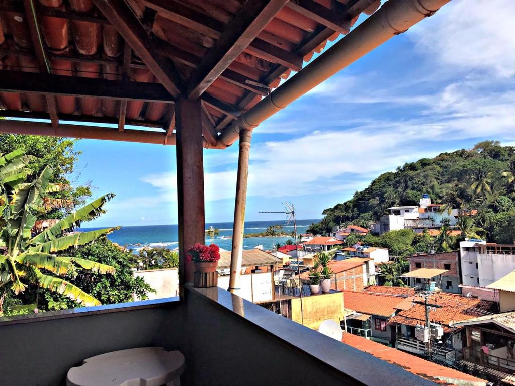 莫罗圣保罗Pousada Morro Tropical的阳台享有大海和建筑的景致。