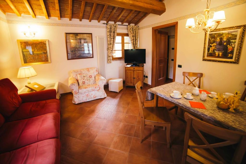 蒙特普齐亚诺Borgo 7 TigliAppartamento a Montepulciano n7的客厅配有红色的沙发和桌子