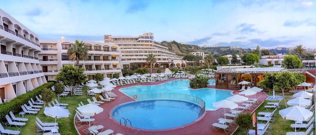 依克希亚Sol Cosmopolitan Rhodes的设有一个大型游泳池和躺椅的度假胜地