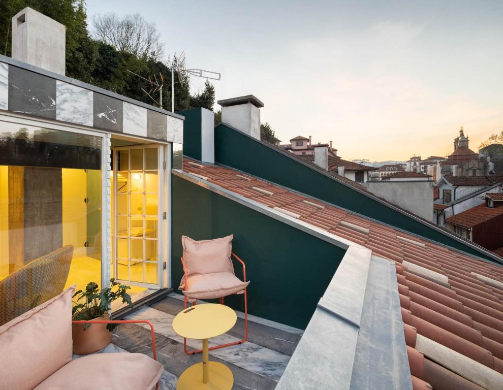阿马兰特Covelo - The Original Rooms and Suites的屋顶上带椅子和桌子的庭院