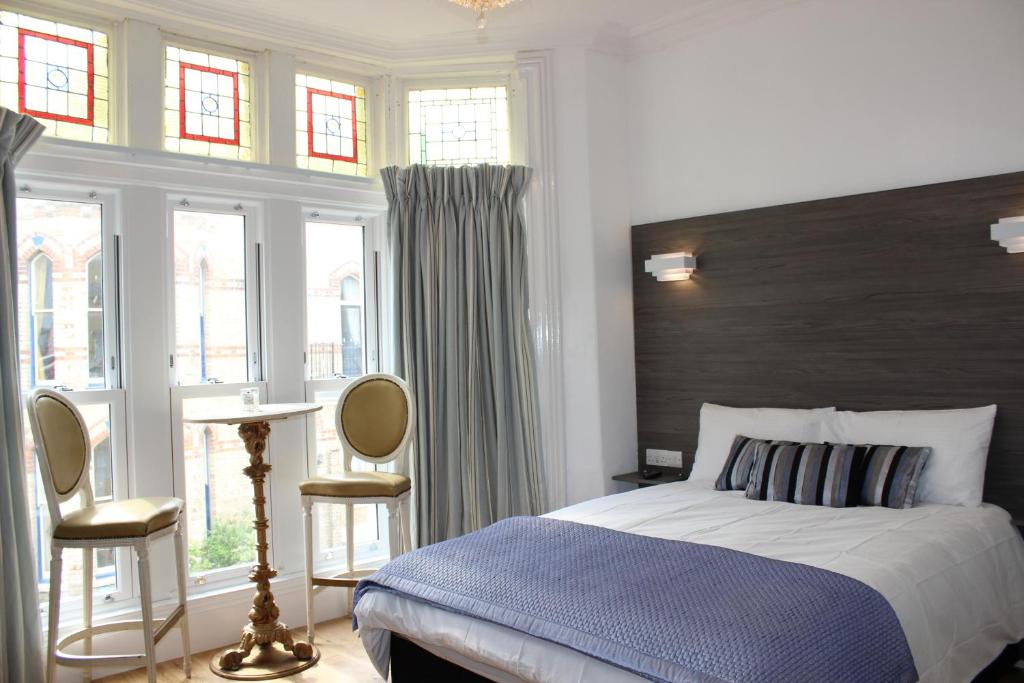 伊尔弗勒科姆Grosvenor House的一间卧室配有一张带蓝色毯子的床和窗户。