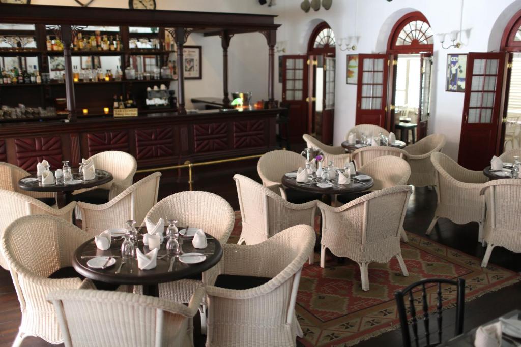康提皇家酒吧加酒店的一间带桌椅的餐厅和一间酒吧