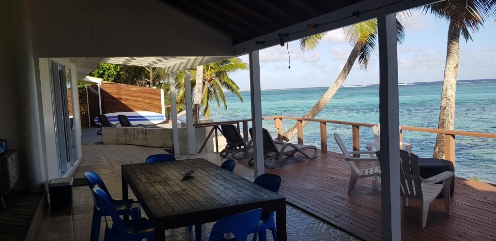 拉罗汤加阿拉帕迪度假屋的一个带桌椅的门廊和大海