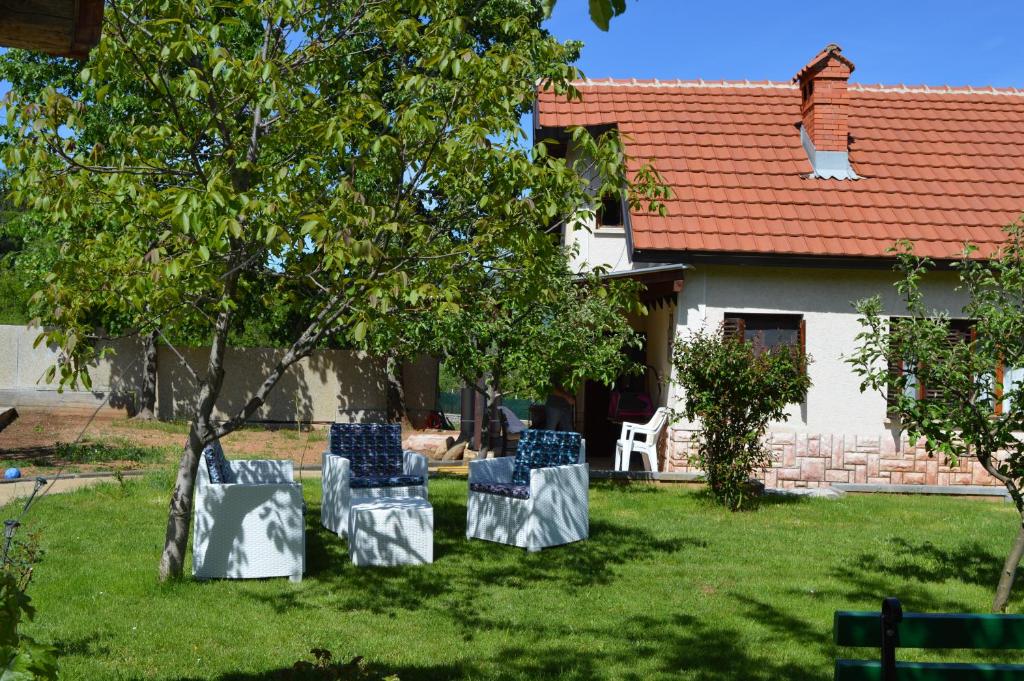 VevčaniMacedonia, Accommodations,rentals"Villa Vevcani" Vevchani的坐在房子前面的草上,有三把椅子