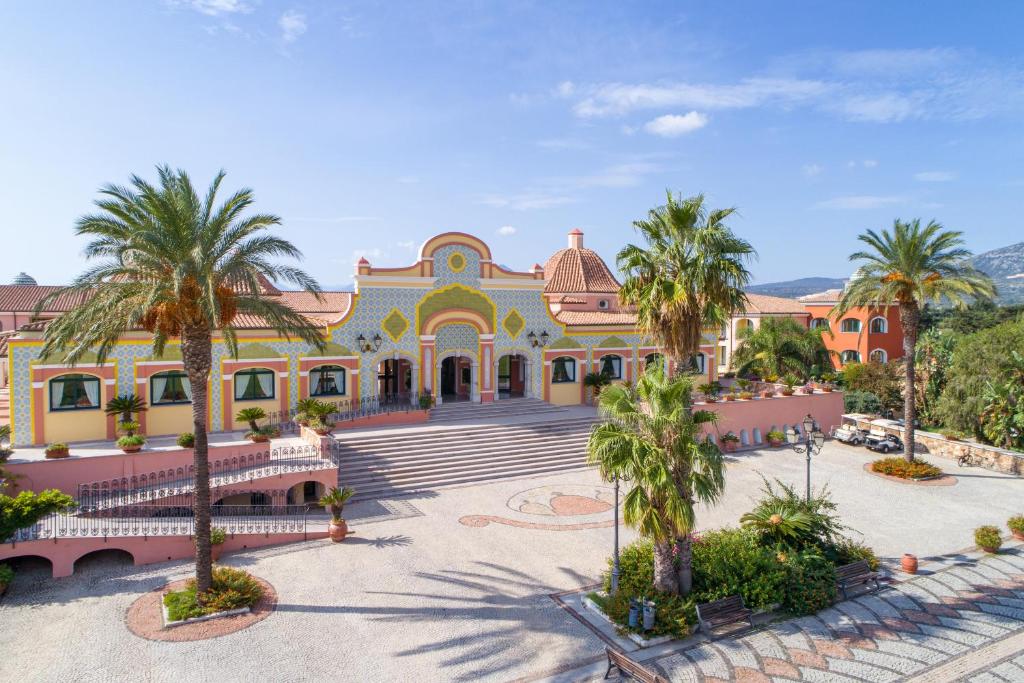 奥罗塞伊马里纳海滩俱乐部酒店的一座棕榈树环绕的大建筑
