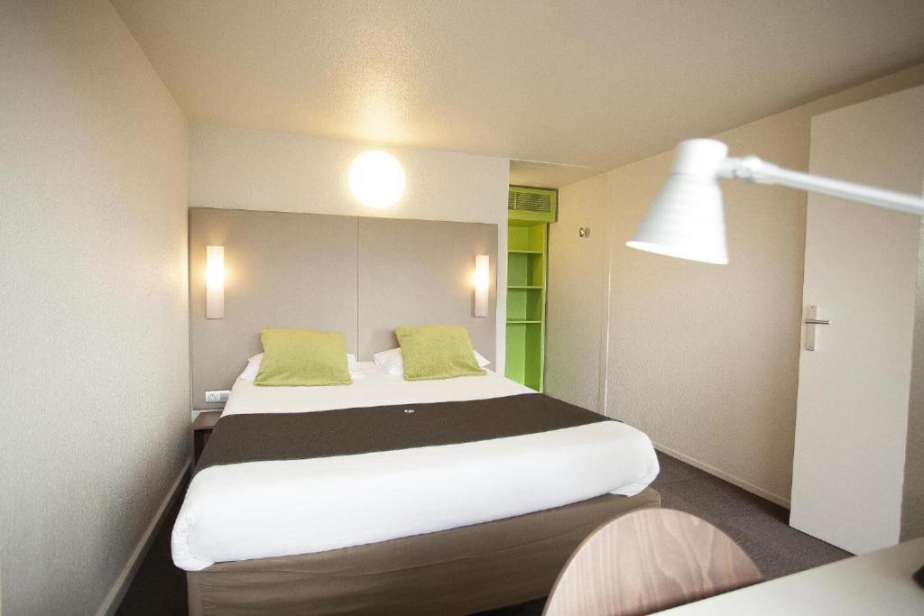 布尔日钟楼布尔杰北圣杜夏尔酒店的卧室配有带绿色枕头的大型白色床
