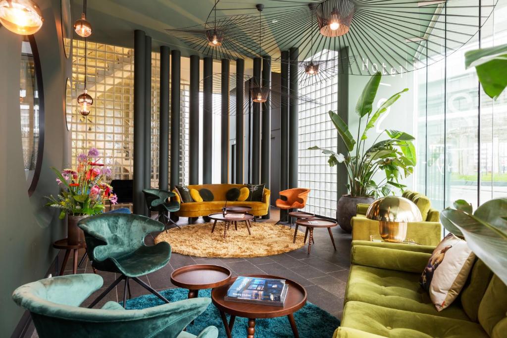 阿姆斯特丹逸居酒店的客厅配有绿色家具和桌椅