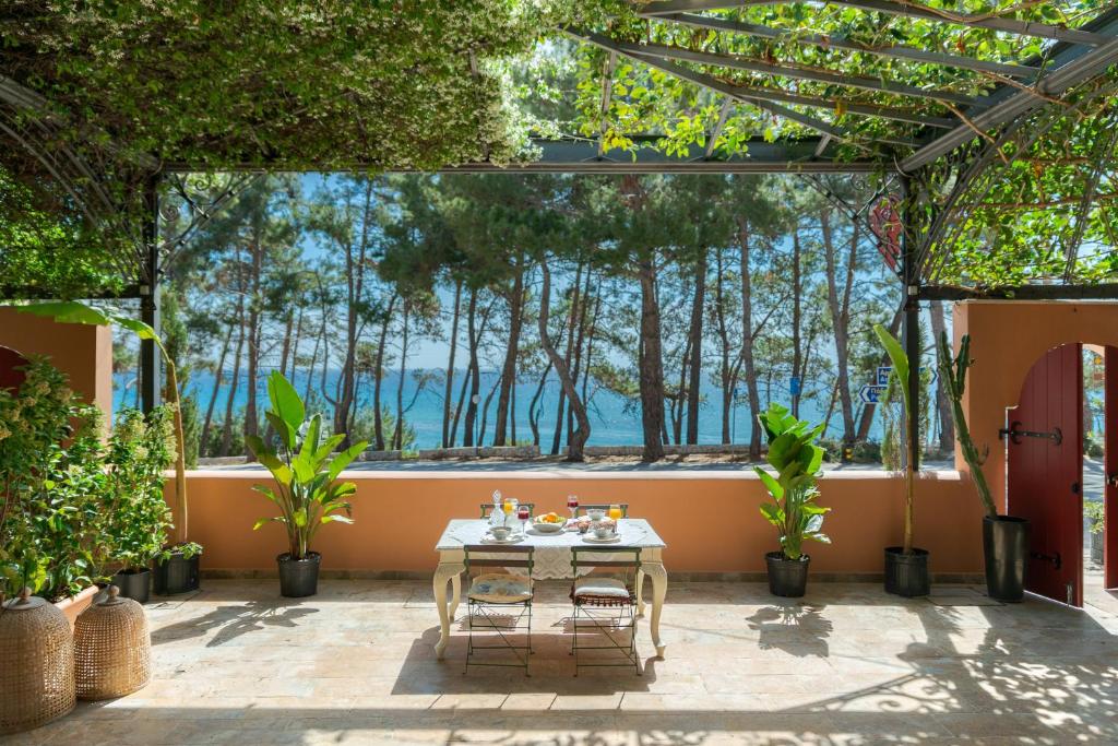 斯卡拉Scorpios Mansion / Downtown Skala / Seaside的庭院配有桌椅和树木