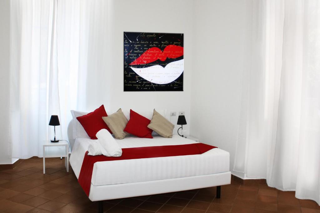 罗马罗马圆形大剧场度假公寓式酒店的一间卧室配有红色和白色枕头的床