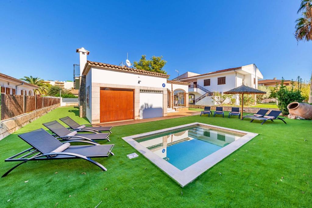 阿尔库迪亚港villa amfora的一个带游泳池、椅子和房子的庭院