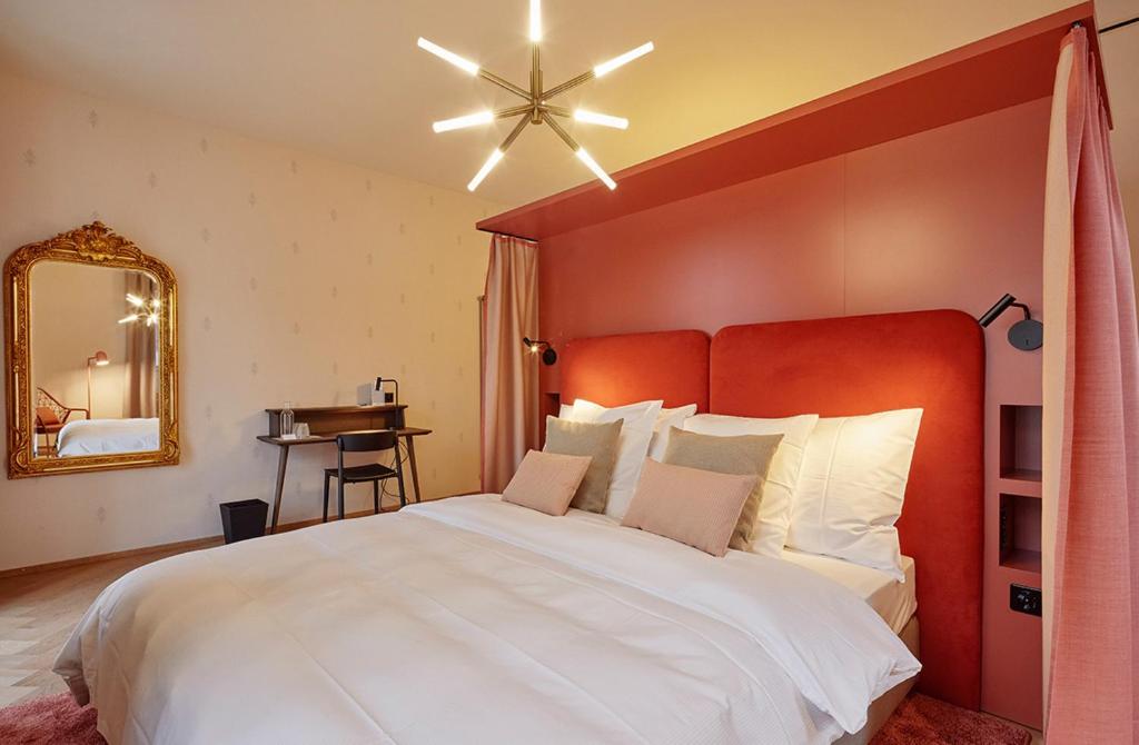 屈斯纳赫特Hotel Restaurant Seehof的一间卧室配有一张白色大床和红色床头板
