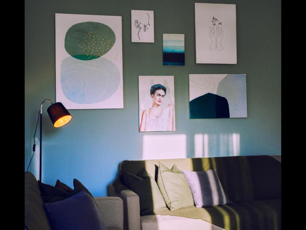 普里诺斯Omalia Apartment的客厅配有沙发和墙上的照片
