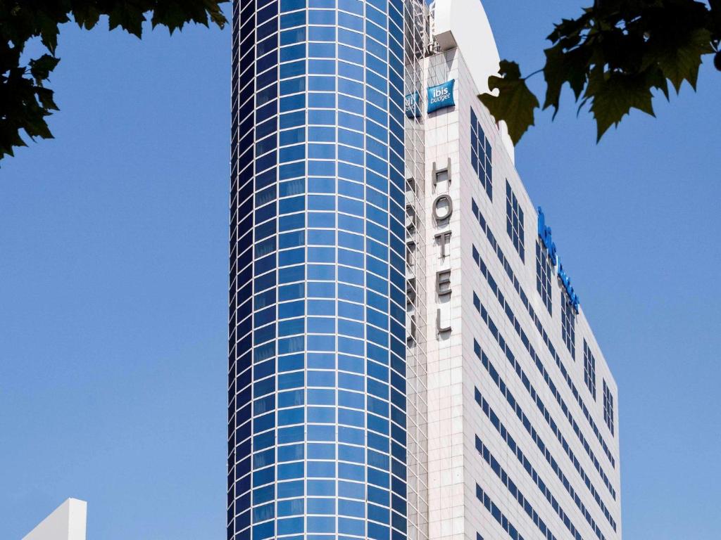 蒙特勒伊巴黎 波特蒙特勒伊德宜必思快捷酒店的一座高大的蓝色和白色建筑,上面有起重机