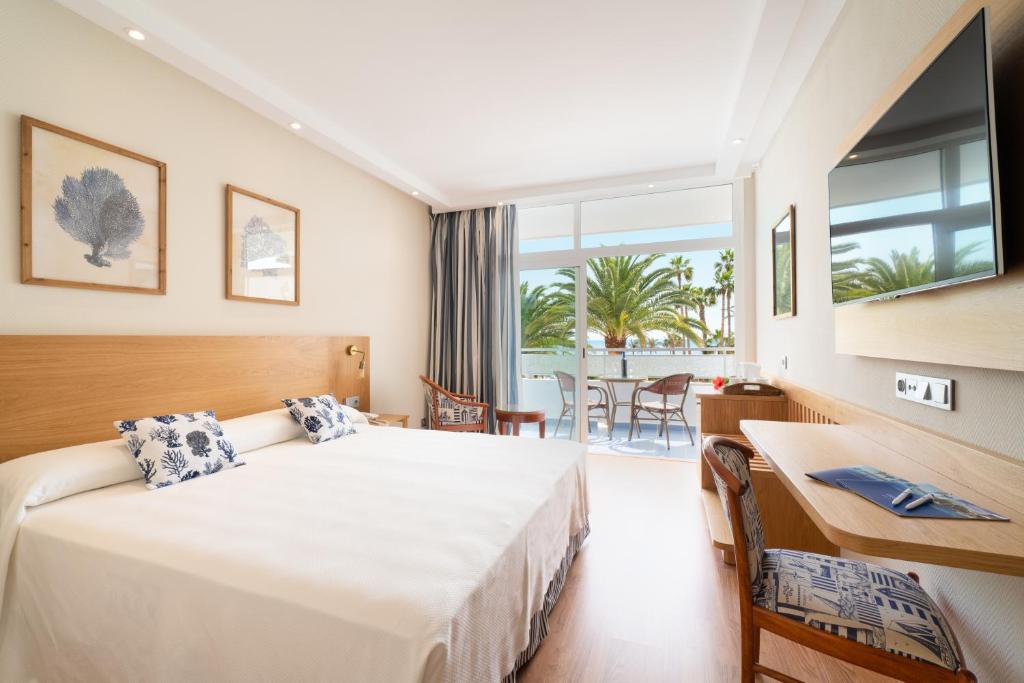 卡门港VK圣安东尼奥酒店的配有一张床、一张书桌和一扇窗户的酒店客房
