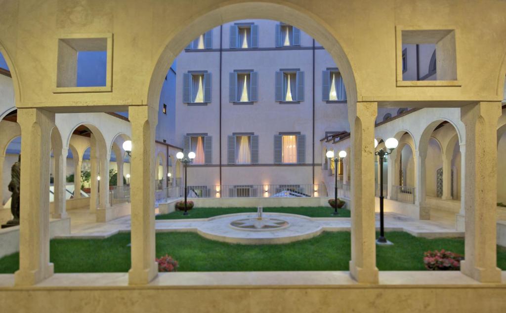 罗马澳大利亚多莫斯酒店的一座带拱门的建筑和一个带喷泉的庭院