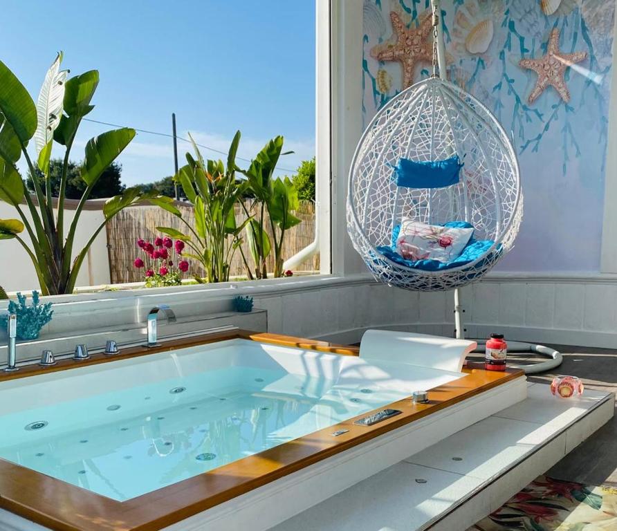 Leporano MarinaResort Villa La Perla Sul Mare的带窗户的客房内的热水浴池