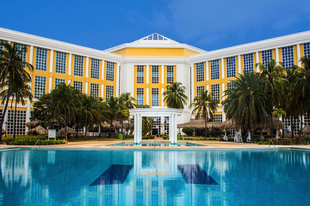La Playa玛格丽塔岛赫斯珀里亚酒店的一座大型建筑,前面设有一个大型游泳池