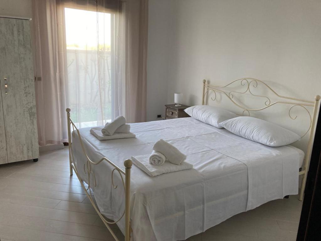 普尔萨诺Casa Ulivo的卧室配有白色床和毛巾
