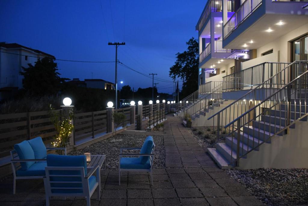 尼基季Theano Luxury Suites Nikiti的夜间人行道上带蓝色椅子的建筑
