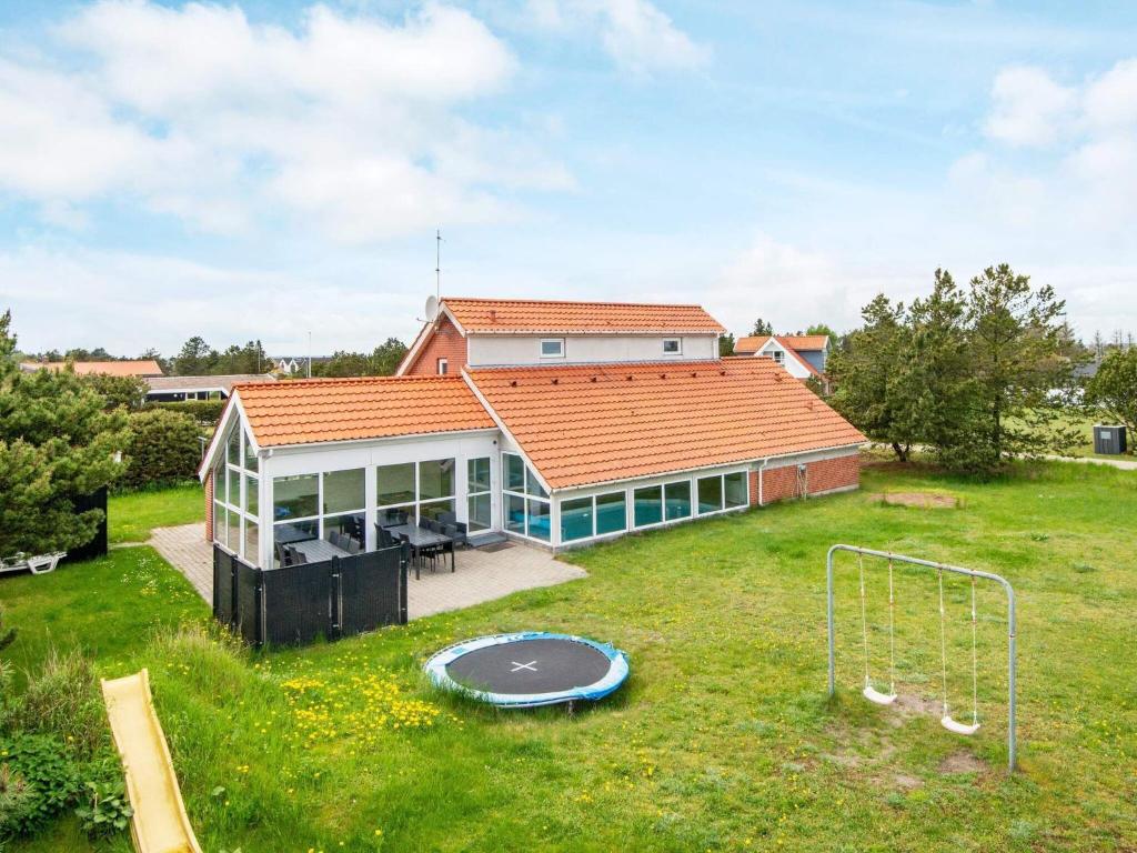 菲耶勒鲁普海滨12 person holiday home in Glesborg的一座带蹦床的大院子的房子