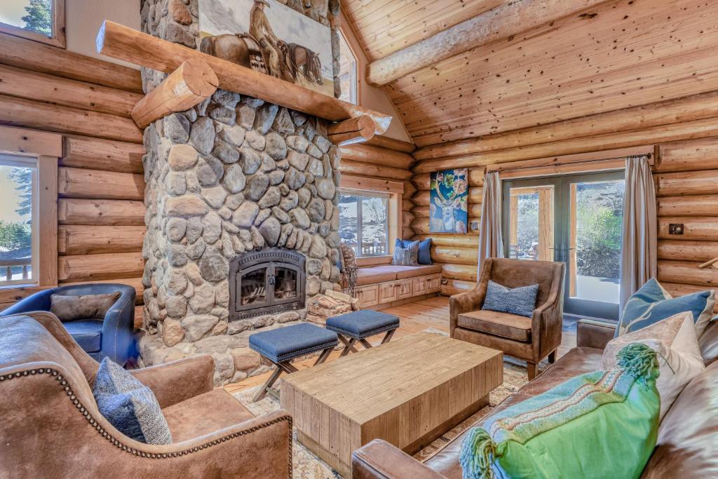 特拉基Log Cabin Estate - Falcon Ridge的小木屋内带石制壁炉的客厅