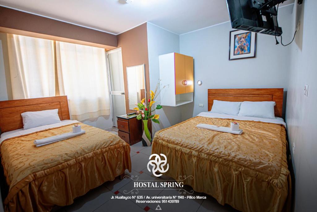 瓦努科Hostal Spring II的酒店客房设有两张床和电视。