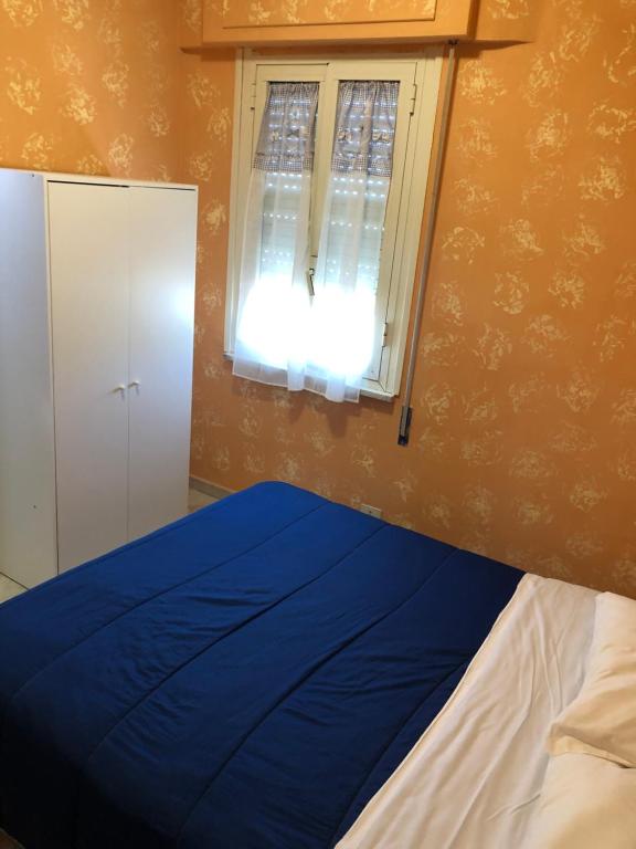 阿尔代亚门廊宾馆的一间卧室设有蓝色的床和窗户。