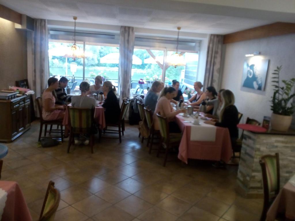 克洛滕Cafe Moselterrasse的一群坐在餐厅桌子上的人