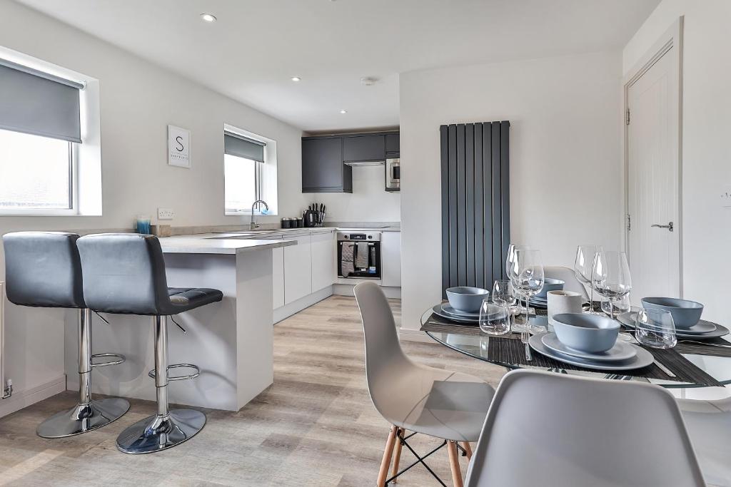 谢菲尔德Newly Renovated 3 Bed Apartment with Parking by Ark SA的厨房以及带桌椅的用餐室。