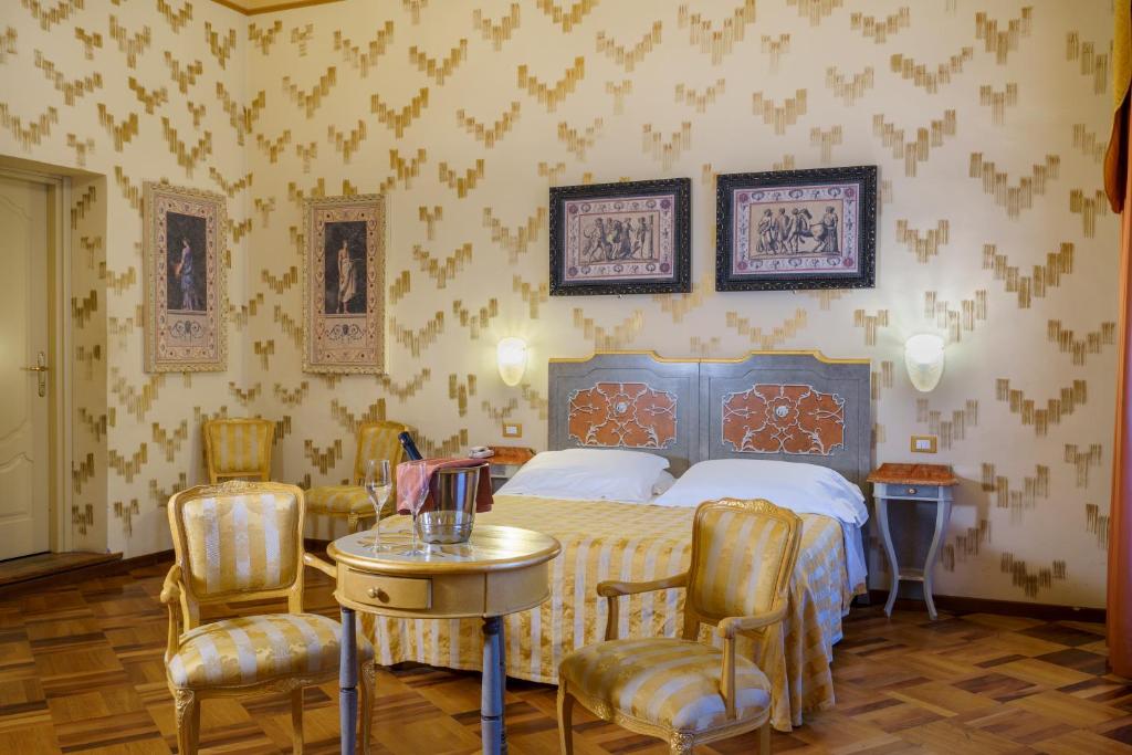 佩鲁贾拉罗赛塔酒店的卧室配有一张床和一张桌子及椅子