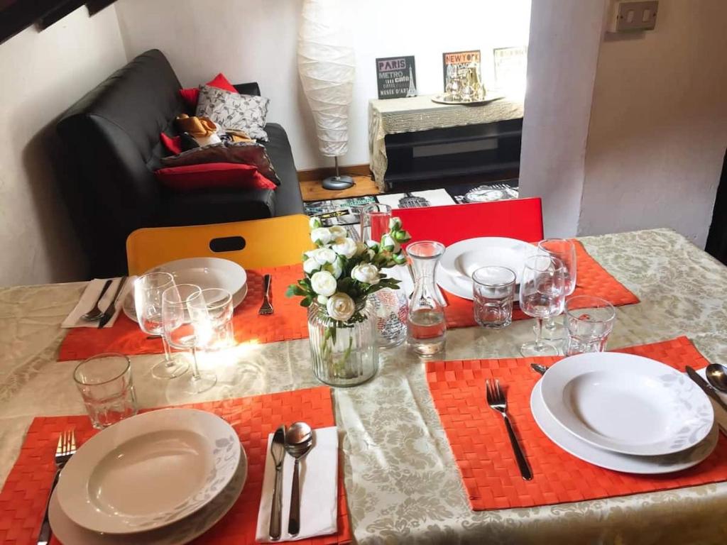 博洛尼亚3-Tourist House Bologna-Mansarda - Self check-in的餐桌,带盘子和玻璃杯,桌布