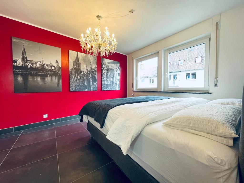 乌尔姆apartment11的红色卧室设有一张大床和吊灯。